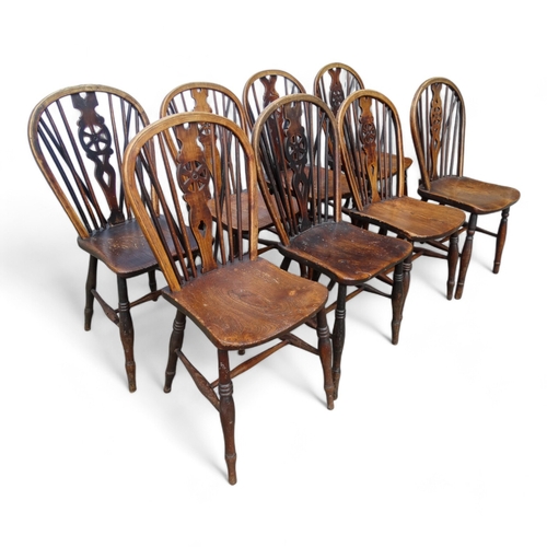 979 - A 19th century harlequin set of eight ash and elm wheel back Thames Valley chairs - with pierced spl... 