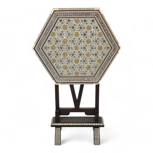 982 - An early 20th century Moorish tilt top table - with a hexagonal top intricately inlaid with bone and... 