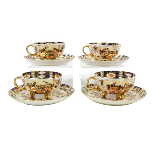 243 - A set of four Royal Crown Derby tea cups and saucers - Imari decorated, the cups raised on gilt ball... 