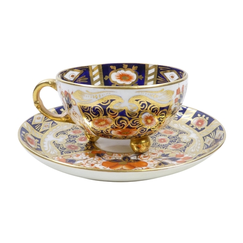 243 - A set of four Royal Crown Derby tea cups and saucers - Imari decorated, the cups raised on gilt ball... 