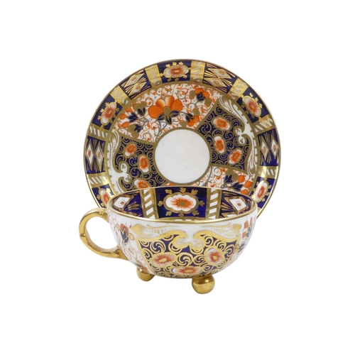 243 - A set of four Royal Crown Derby tea cups and saucers - Imari decorated, the cups raised on gilt ball... 