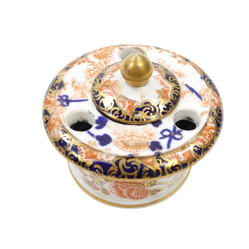 253 - A Royal Crown Derby inkwell - circular with cover and decorated in the Imari style, 8cm diameter, to... 