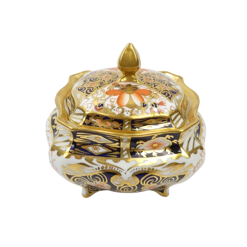 253 - A Royal Crown Derby inkwell - circular with cover and decorated in the Imari style, 8cm diameter, to... 