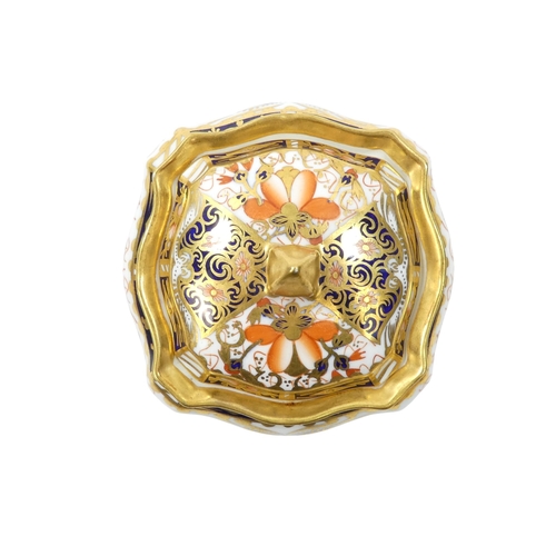 253 - A Royal Crown Derby inkwell - circular with cover and decorated in the Imari style, 8cm diameter, to... 