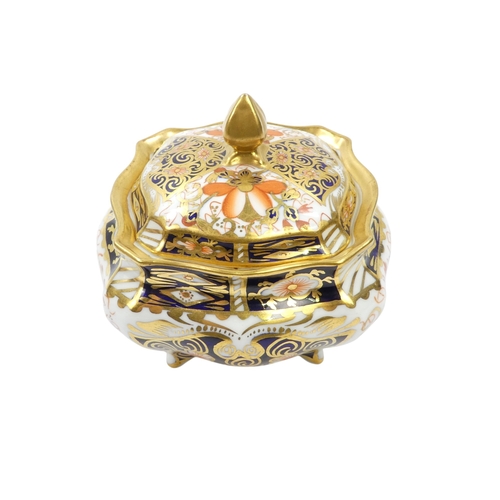 253 - A Royal Crown Derby inkwell - circular with cover and decorated in the Imari style, 8cm diameter, to... 