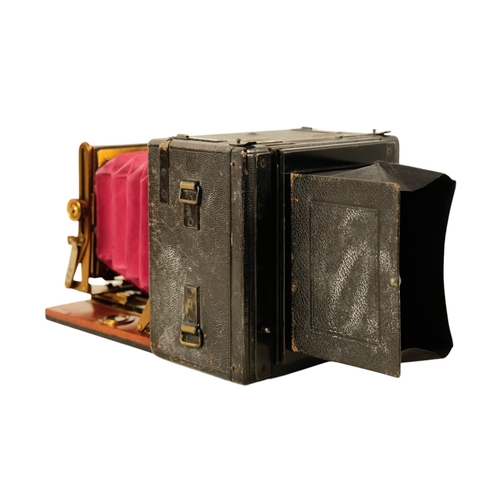 26 - A Sanderson deluxe field camera - the mahogany body with black resin cover, featuring red bellows fi... 