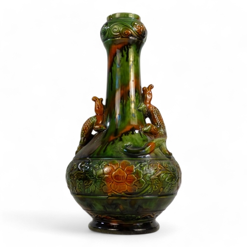 332 - A late 19th century bottle shaped vase - green and treacle glaze, with an impressed foliate band and... 