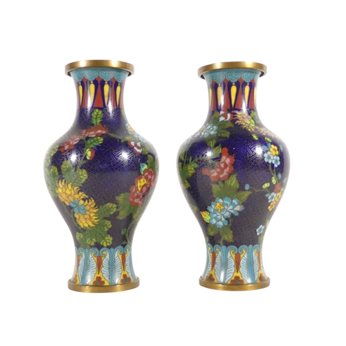 334 - A pair of early 20th century cloisonne vases - of baluster form, decorated with flowers on a blue gr... 