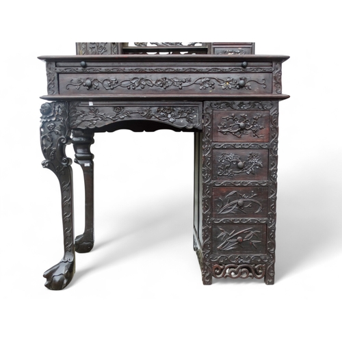 340 - An early 20th century oriental carved hardwood desk - of asymmetrical form incorporating pierced pan... 