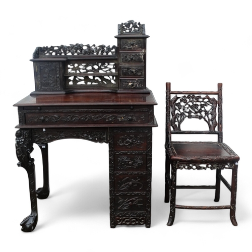 340 - An early 20th century oriental carved hardwood desk - of asymmetrical form incorporating pierced pan... 