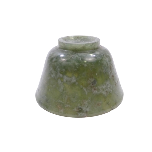 342 - A Chinese spinach jade bowl - with slightly overted rim and raised on a foot, 6cm diameter.