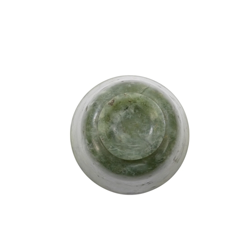 342 - A Chinese spinach jade bowl - with slightly overted rim and raised on a foot, 6cm diameter.