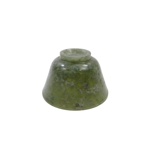 342 - A Chinese spinach jade bowl - with slightly overted rim and raised on a foot, 6cm diameter.