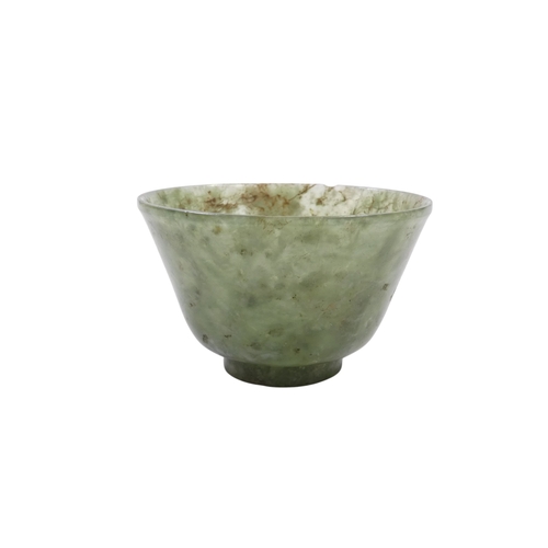 342 - A Chinese spinach jade bowl - with slightly overted rim and raised on a foot, 6cm diameter.