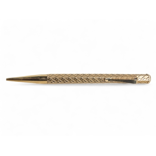 578 - A 9ct gold pencil - hexagonal with engine turning and a vacant cartouche, retailed by Wilson & Gill,... 