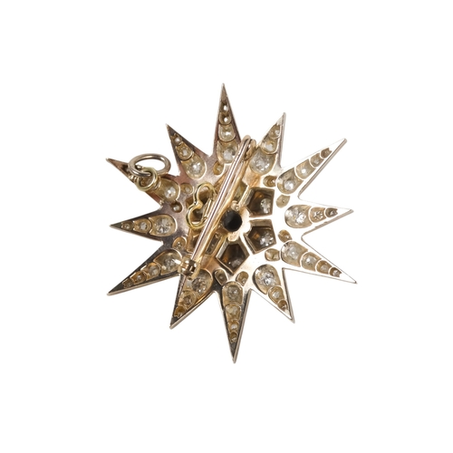 579 - A diamond star pendant/brooch - stepped around a central stone on a twelve point star, 22.1g.