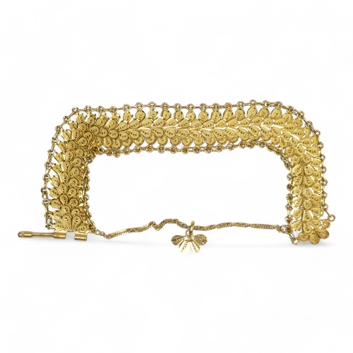 584 - A yellow metal bracelet - of pierced foliate form linked by chain, stamped 21ct, 37.8g.