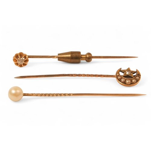 602 - A diamond set stick pin - claw set, together with a star and crescent stick pin and a pearl stick pi... 