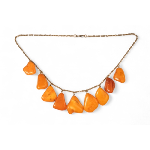 613 - An amber necklace on a white metal chain - with nine polished butterscotch amber drops, together wit... 