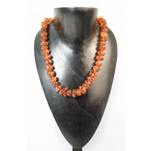 615 - A string of bullet shaped graduated amber beads - length 76cm.