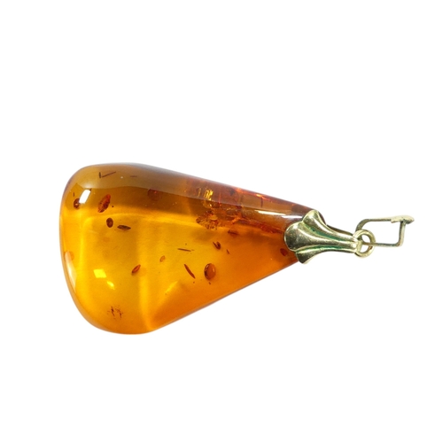 627 - An amber pendant - of polished triangular form, on a 9ct belcher link chain, 11.1g.