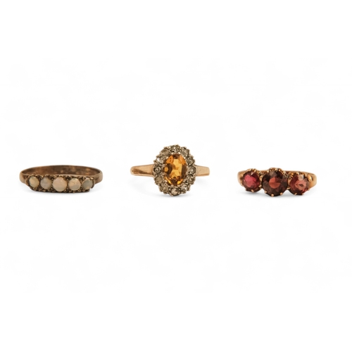 631 - A 9ct gold three stone garnet ring - claw set, size N, together with two further dress rings, 5.8g. ... 