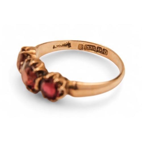 631 - A 9ct gold three stone garnet ring - claw set, size N, together with two further dress rings, 5.8g. ... 