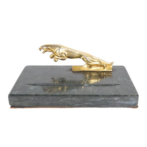 75 - A marble pen tray - mounted with a leaping Jaguar, 18cm wide.