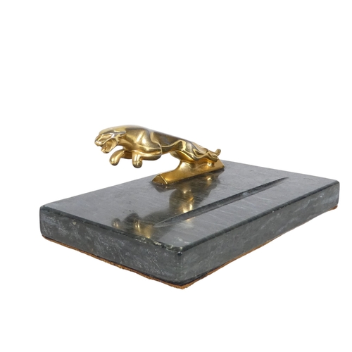 75 - A marble pen tray - mounted with a leaping Jaguar, 18cm wide.