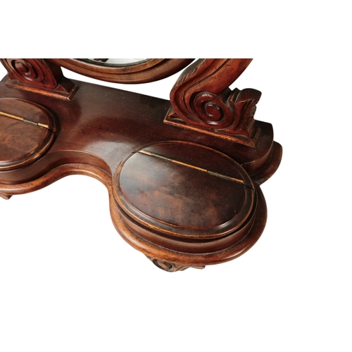 933 - A Victorian mahogany toilet mirror - the oval plate between curved supports, the base incorporating ... 