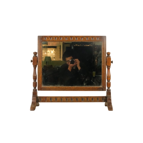 934 - A 17th century style oak toilet mirror - with a rectangular plate and fluted carving between turned ... 