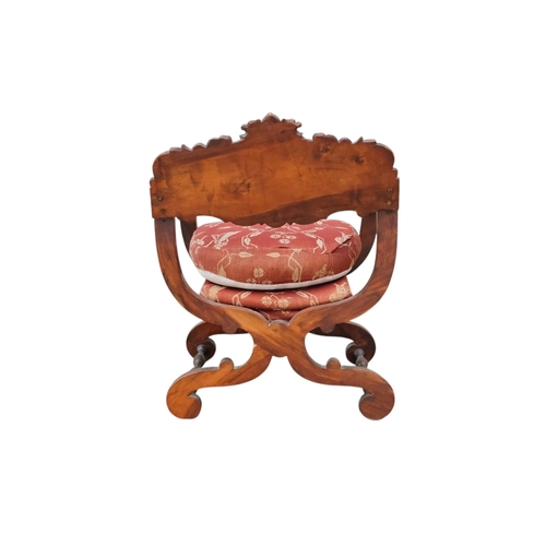 942 - A 17th century style continental walnut Savonarola chair - with carved lion mask finials.