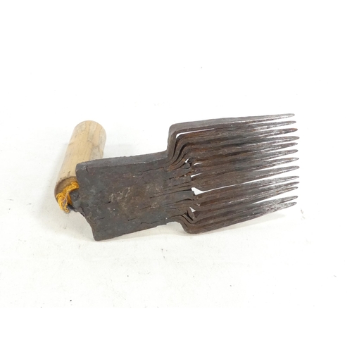 20 - A pair of teasing combs - the tines set in horn and mounted on wooden handles, together with another... 