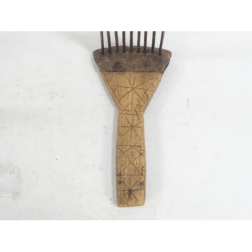 20 - A pair of teasing combs - the tines set in horn and mounted on wooden handles, together with another... 