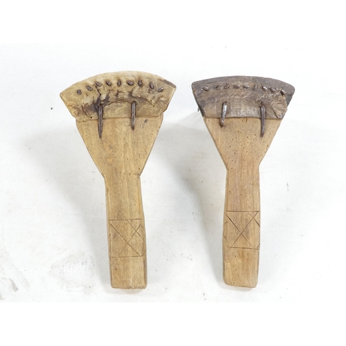 20 - A pair of teasing combs - the tines set in horn and mounted on wooden handles, together with another... 