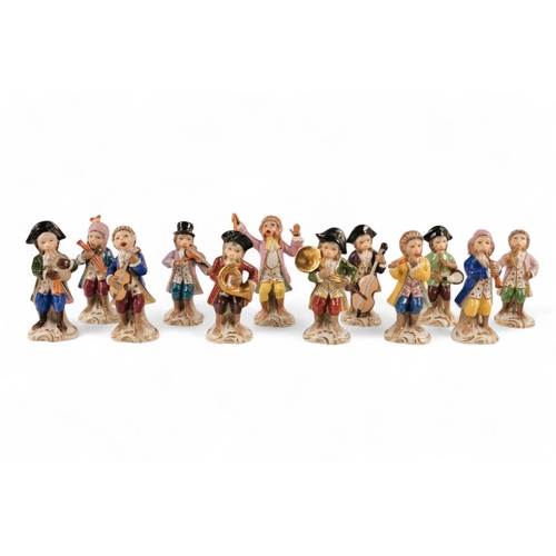 223 - A Sitzendorf Meissen style monkey band - comprising a conductor and eleven musicians, each approx 10... 