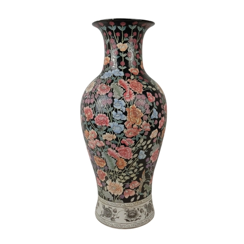 226 - A large baluster shaped vase - decorated in enamels with chrysanthemums and flowers on a black groun... 