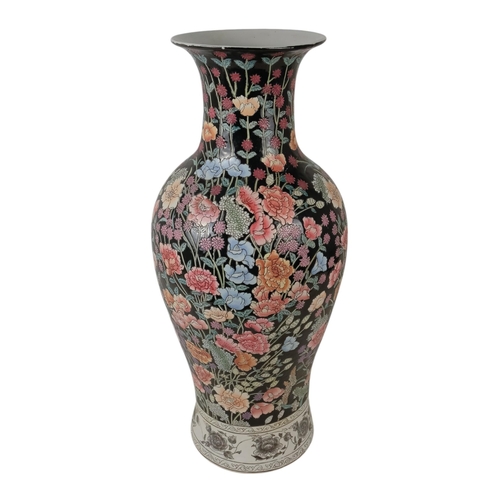 226 - A large baluster shaped vase - decorated in enamels with chrysanthemums and flowers on a black groun... 