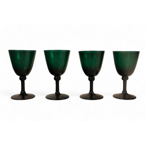 230 - A set of green glasses - with U-shaped bowls and raised on a narrow stems and circular foot, 14cm hi... 