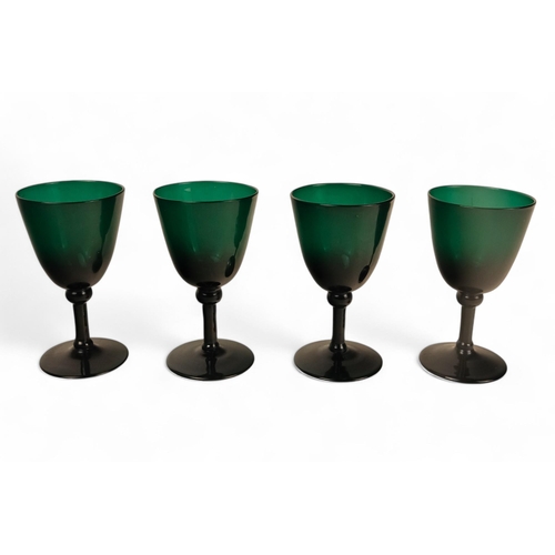 230 - A set of green glasses - with U-shaped bowls and raised on a narrow stems and circular foot, 14cm hi... 