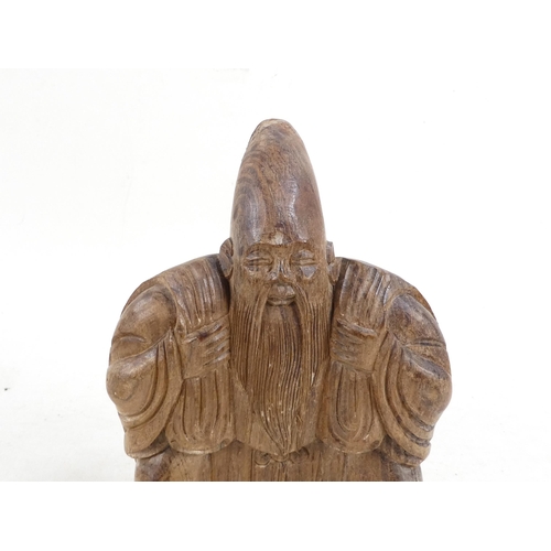 301 - A Chinese caved hardwood deity - the rear carved as a turtle, 20cm high.