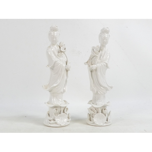 302 - A pair of Chinese Blanc de Chine Guanyin figures - standing on foliate bases and holding lotus flowe... 