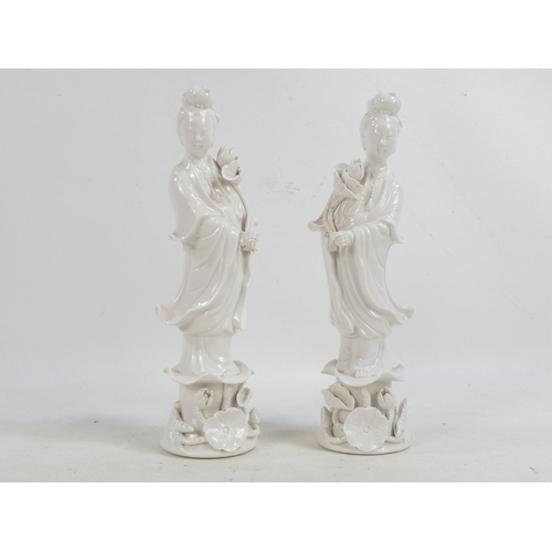 302 - A pair of Chinese Blanc de Chine Guanyin figures - standing on foliate bases and holding lotus flowe... 