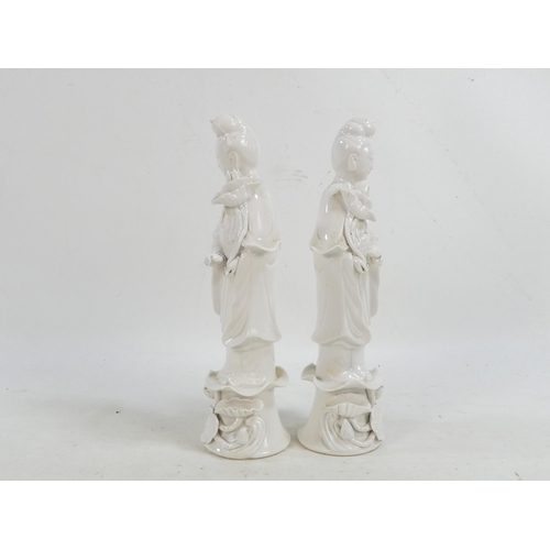 302 - A pair of Chinese Blanc de Chine Guanyin figures - standing on foliate bases and holding lotus flowe... 