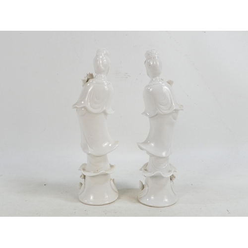 302 - A pair of Chinese Blanc de Chine Guanyin figures - standing on foliate bases and holding lotus flowe... 