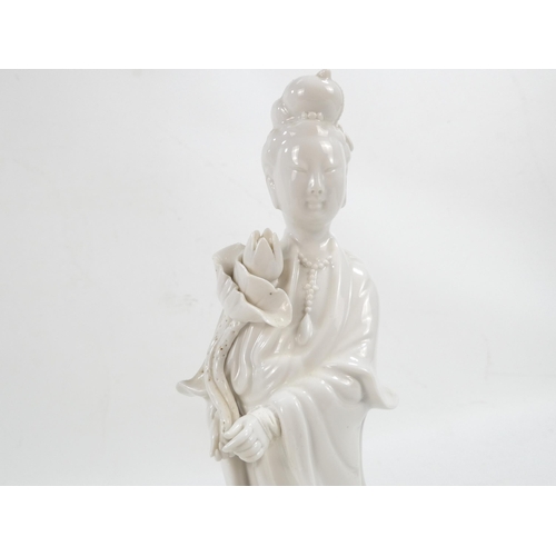 302 - A pair of Chinese Blanc de Chine Guanyin figures - standing on foliate bases and holding lotus flowe... 