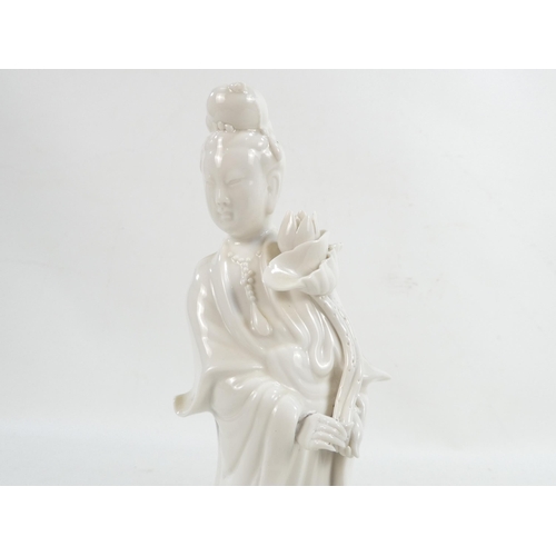 302 - A pair of Chinese Blanc de Chine Guanyin figures - standing on foliate bases and holding lotus flowe... 