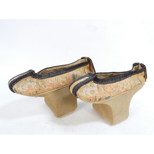 305 - A pair of early 20th century Chinese Manchu platform shoes - the upper with a floral silk design on ... 