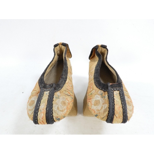 305 - A pair of early 20th century Chinese Manchu platform shoes - the upper with a floral silk design on ... 