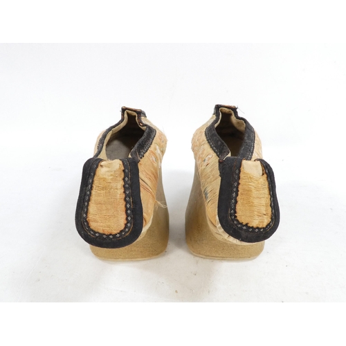 305 - A pair of early 20th century Chinese Manchu platform shoes - the upper with a floral silk design on ... 